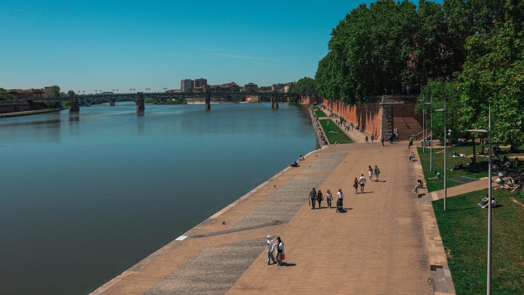 People strolling by the Garonne River in Toulouse, France on a clear day. Location Food truck Toulouse