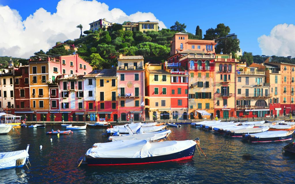 A vibrant view of the colorful waterfront in Nice, France with boats docked along the sea. Location food truck Nice
